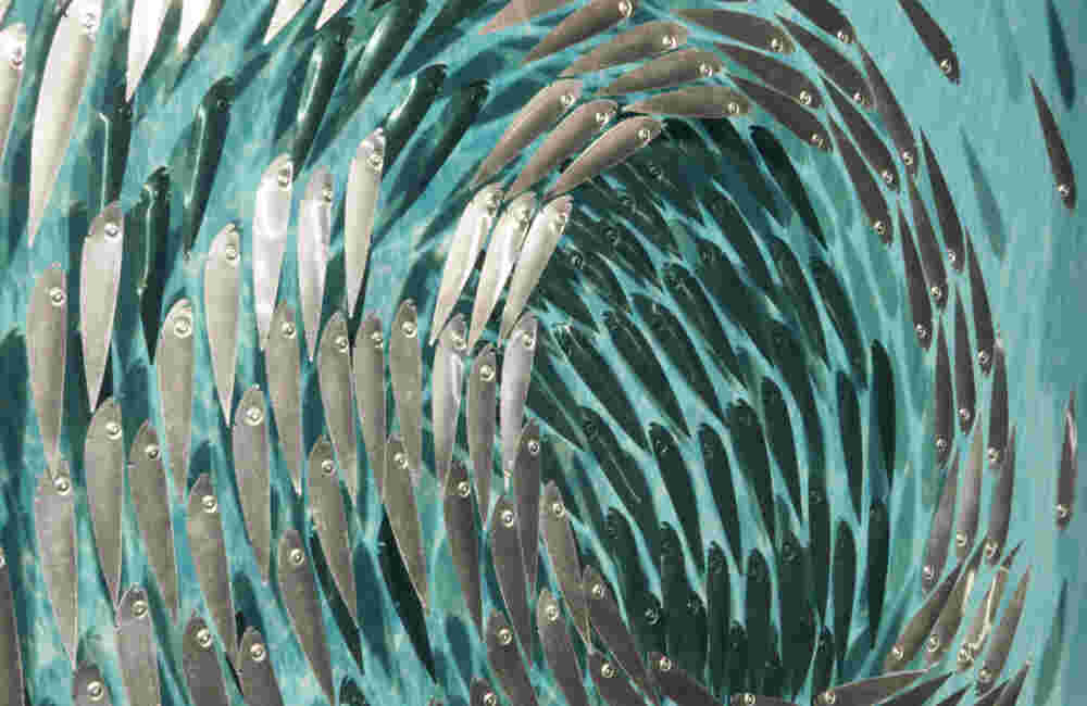 A 136 Three-dimensional wall sculpture, school of fish theme, with layers of plexiglass, aluminum frame and swirling copper fish.