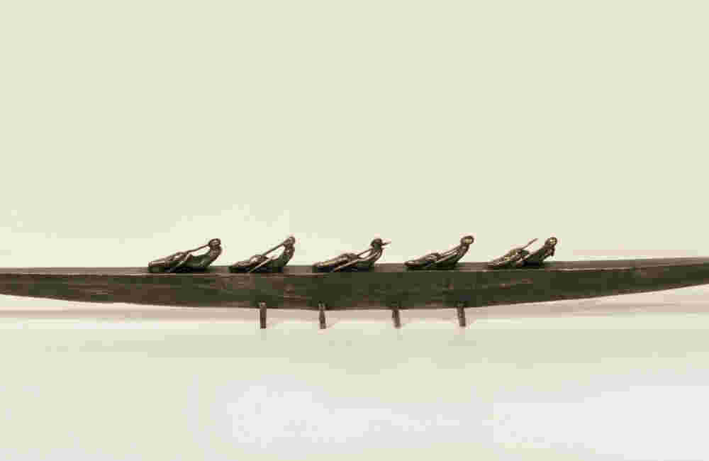 Small boat sculpture made of cast bronze.