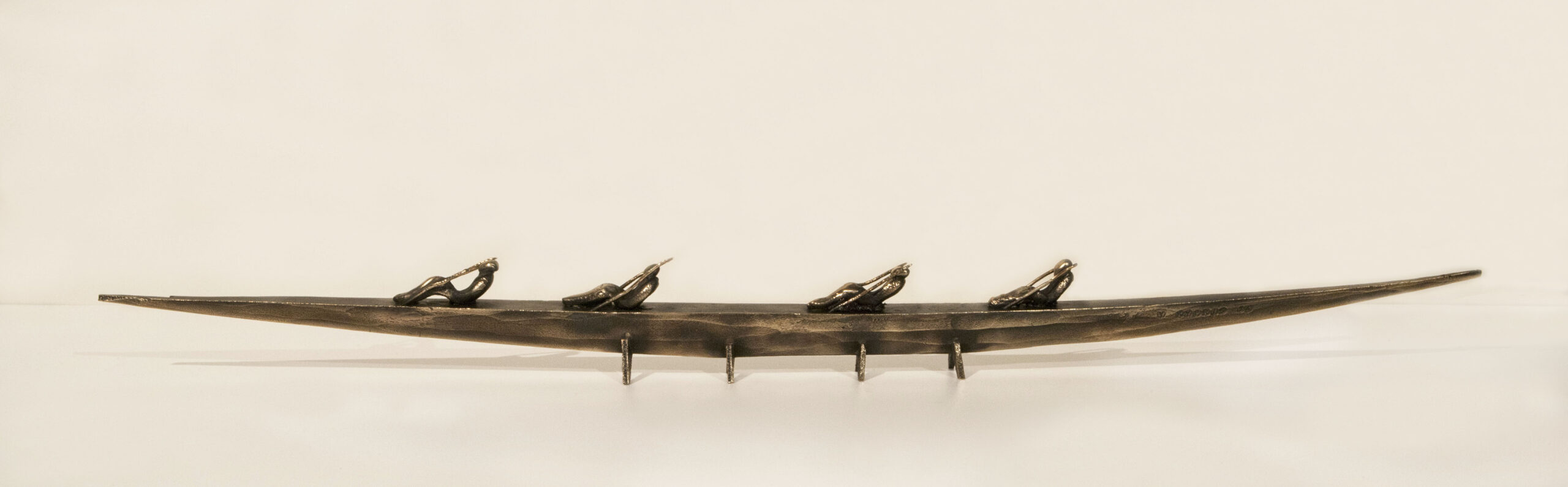 Small boat sculpture made of cast bronze.