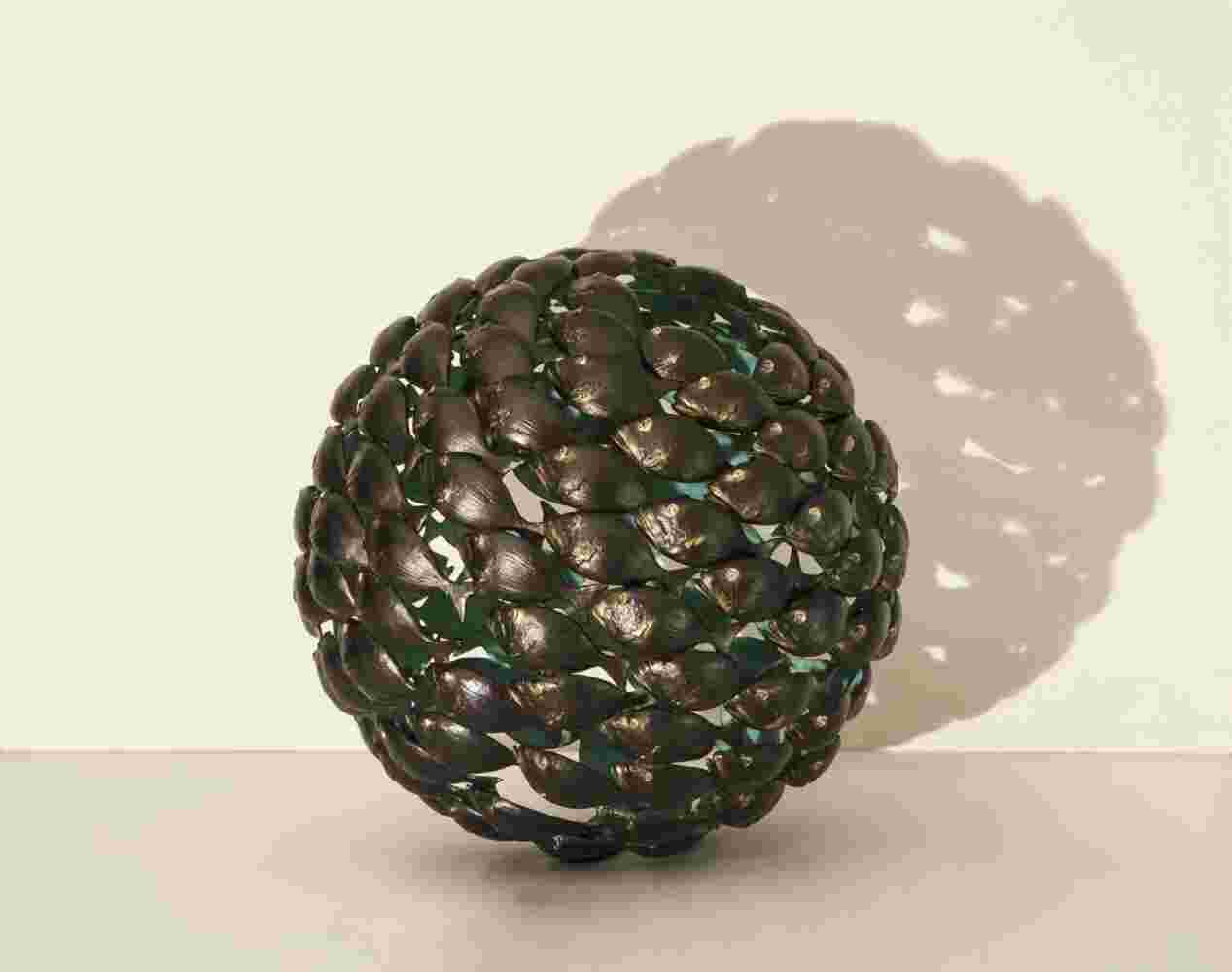 Bronze fish shoal ball with a green interior made of cast bronze