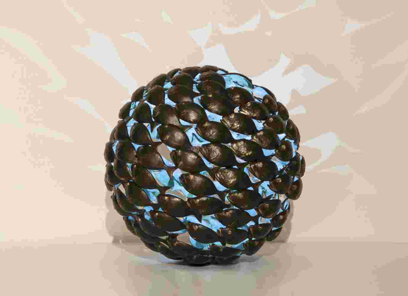 Bronze fish shoal ball with a green interior made of cast bronze