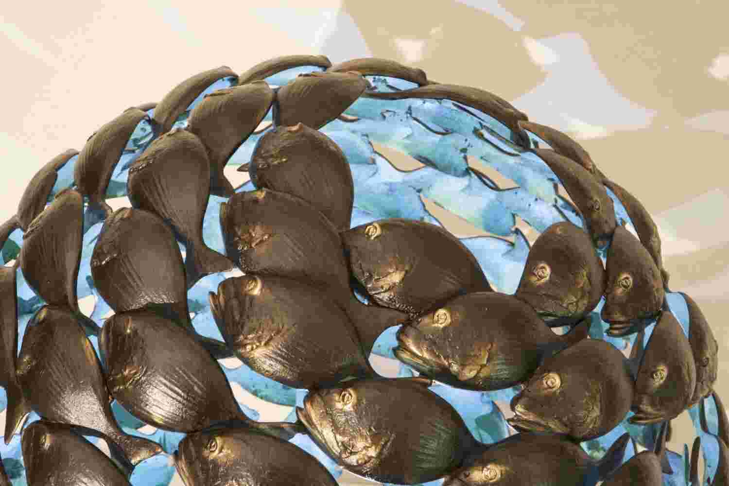 Bronze fish shoal ball with a green interior made of cast bronze