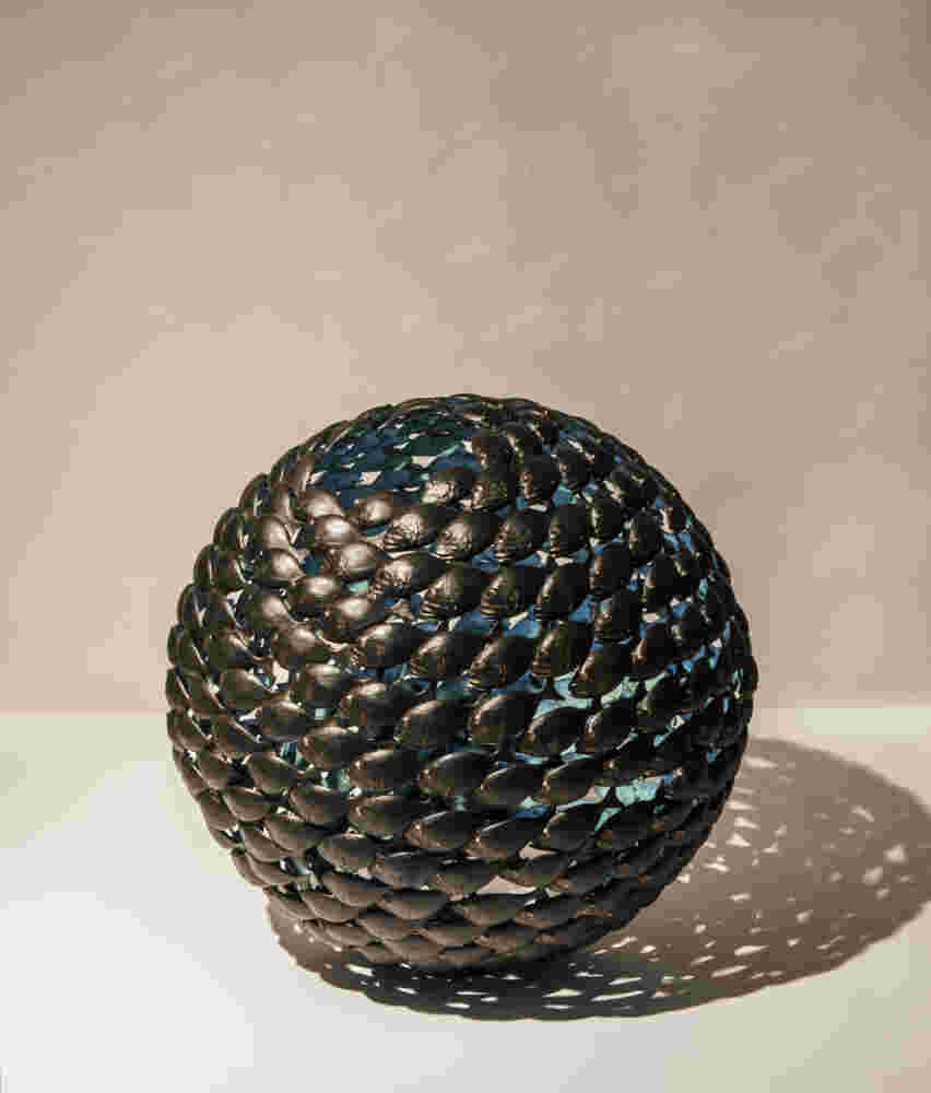 Bronze fish shoal ball with a green interior made of cast bronze