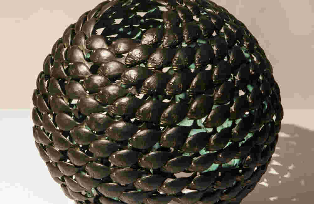 Bronze fish shoal ball with a green interior made of cast bronze