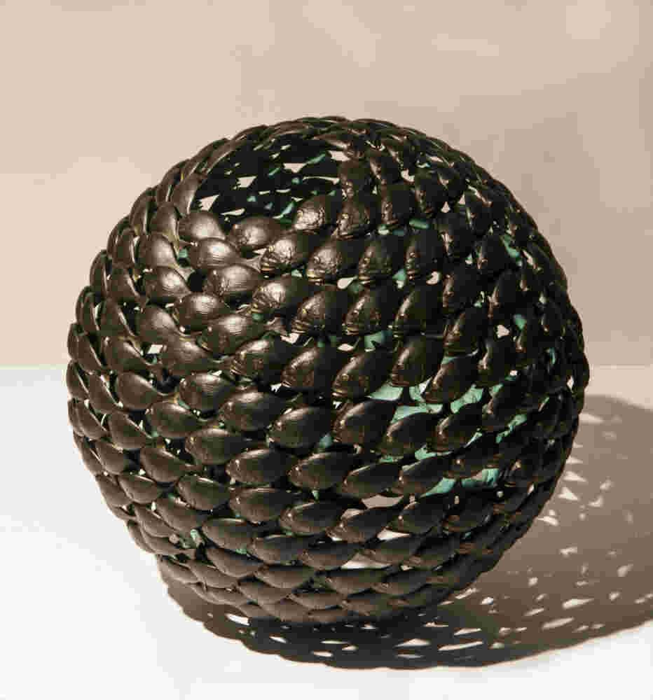 Bronze fish shoal ball with a green interior made of cast bronze
