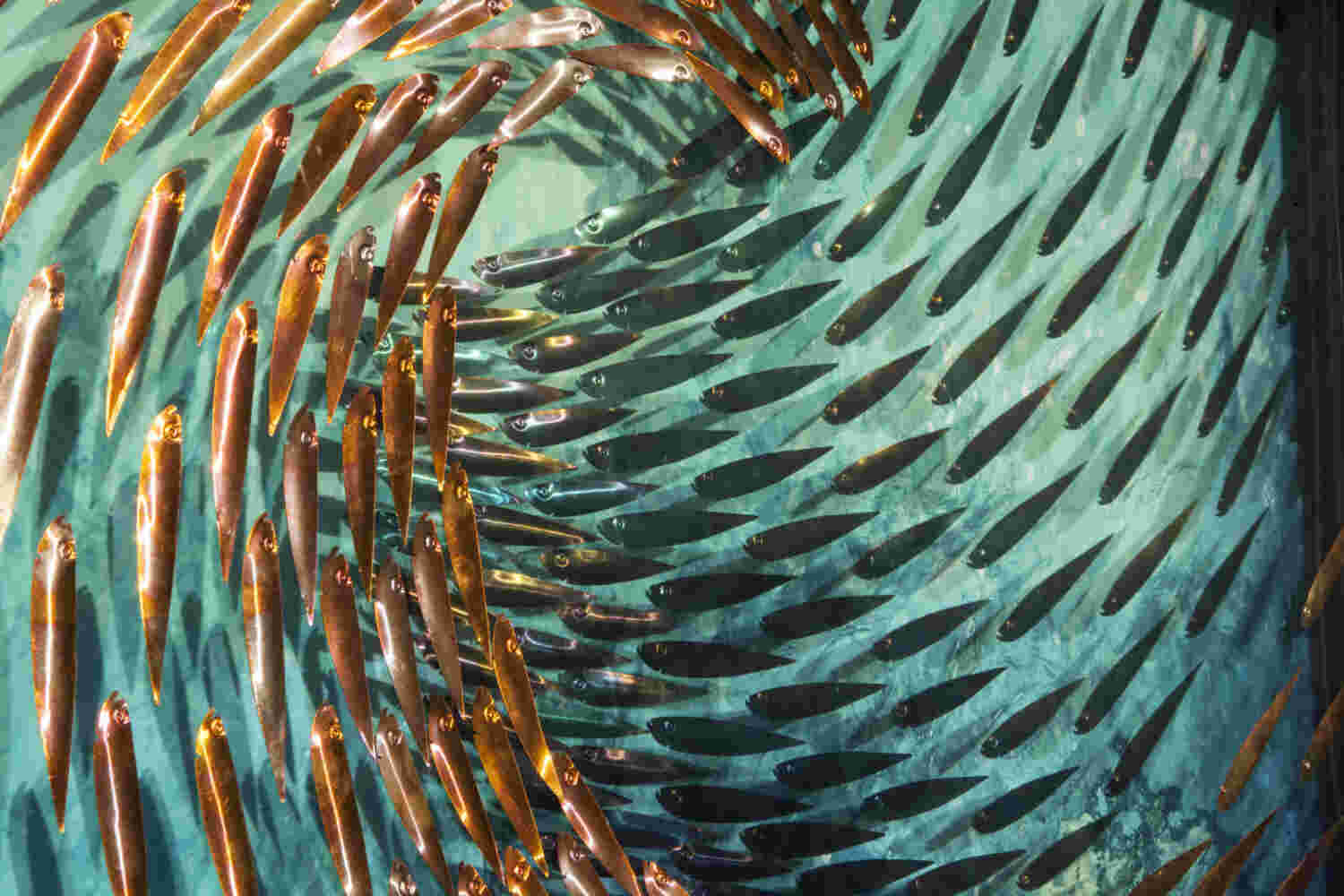 Three-dimensional wall sculpture, school of fish theme, with layers of plexiglass, aluminum frame and swirling copper fish.
