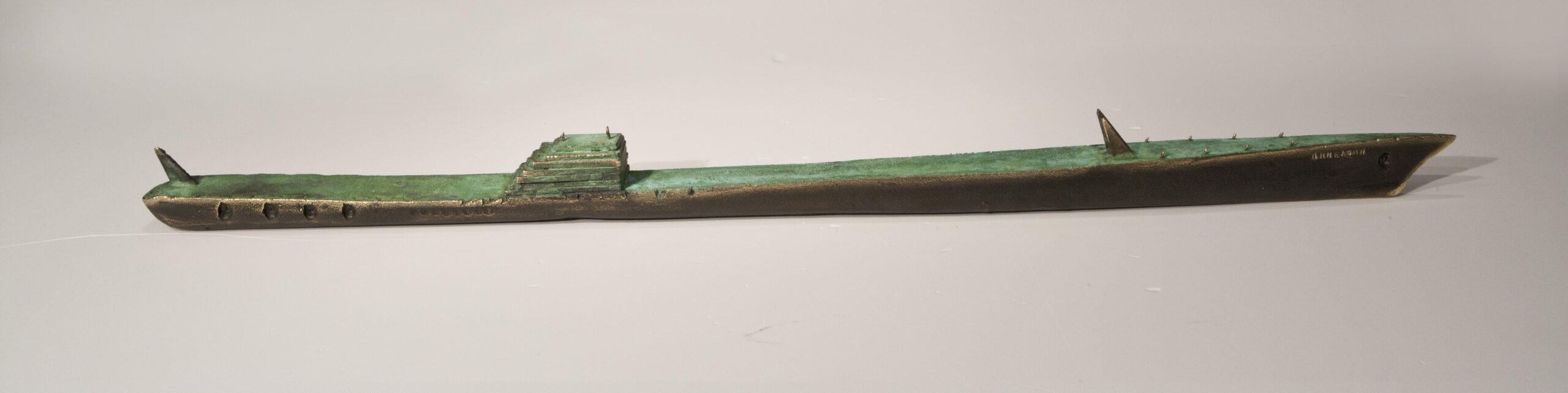 Small boat sculpture made of cast bronze.