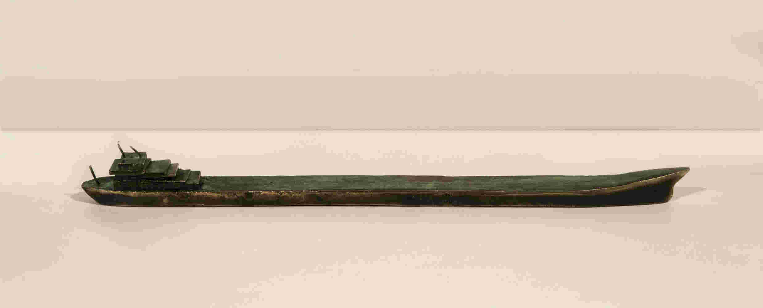 Small boat sculpture made of cast bronze.
