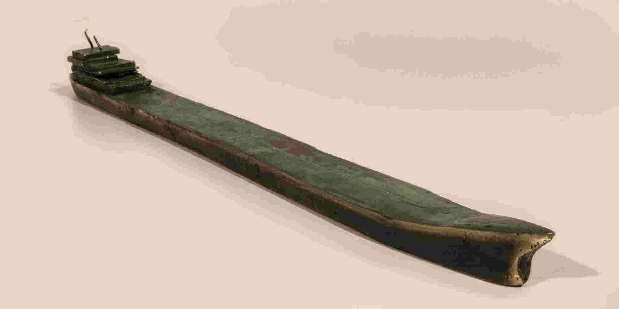 Small boat sculpture made of cast bronze.