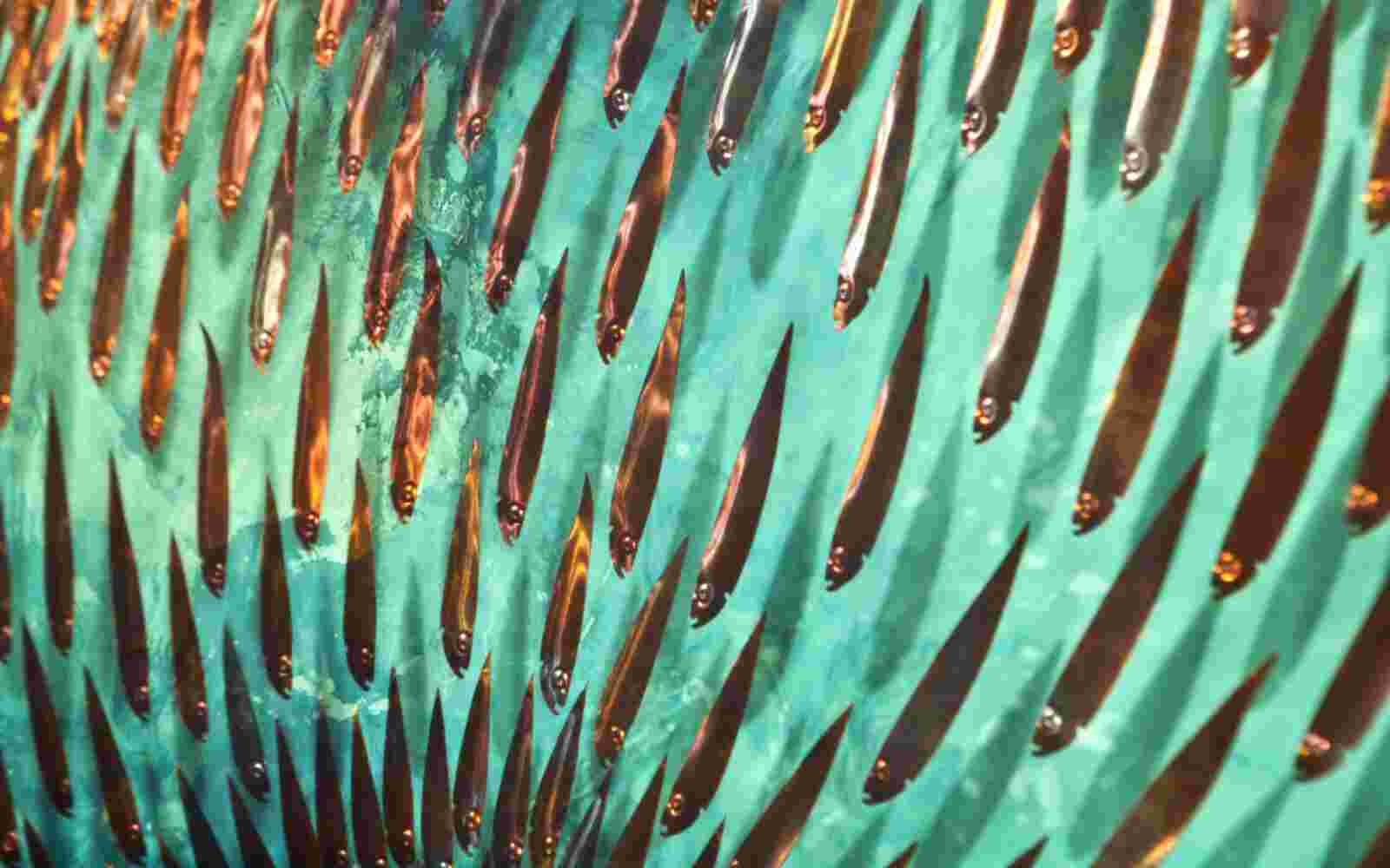 Three-dimensional wall sculpture, school of fish theme, with layers of plexiglass, aluminum frame and fishball of aluminum and copper fish.