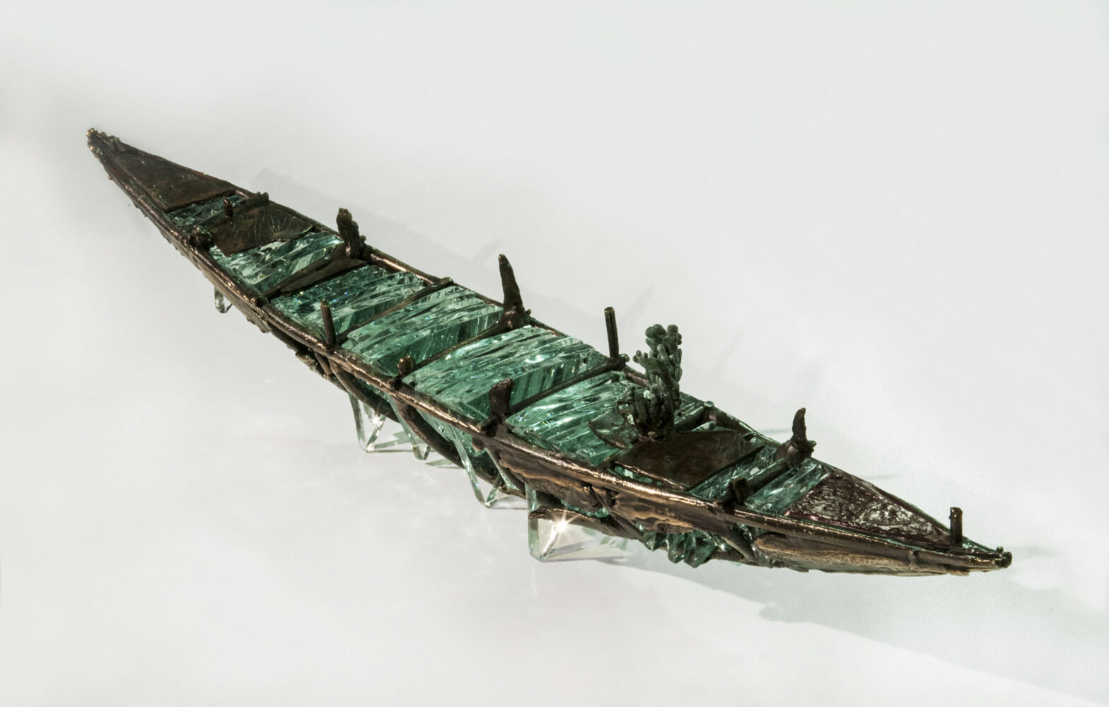 Shipwreck boat sculpture made of hand cut glass and bronze.