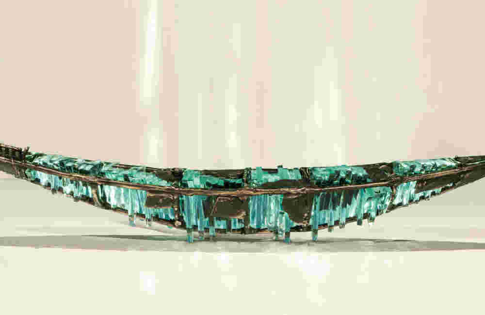 Shipwreck boat sculpture made of hand cut glass and bronze.
