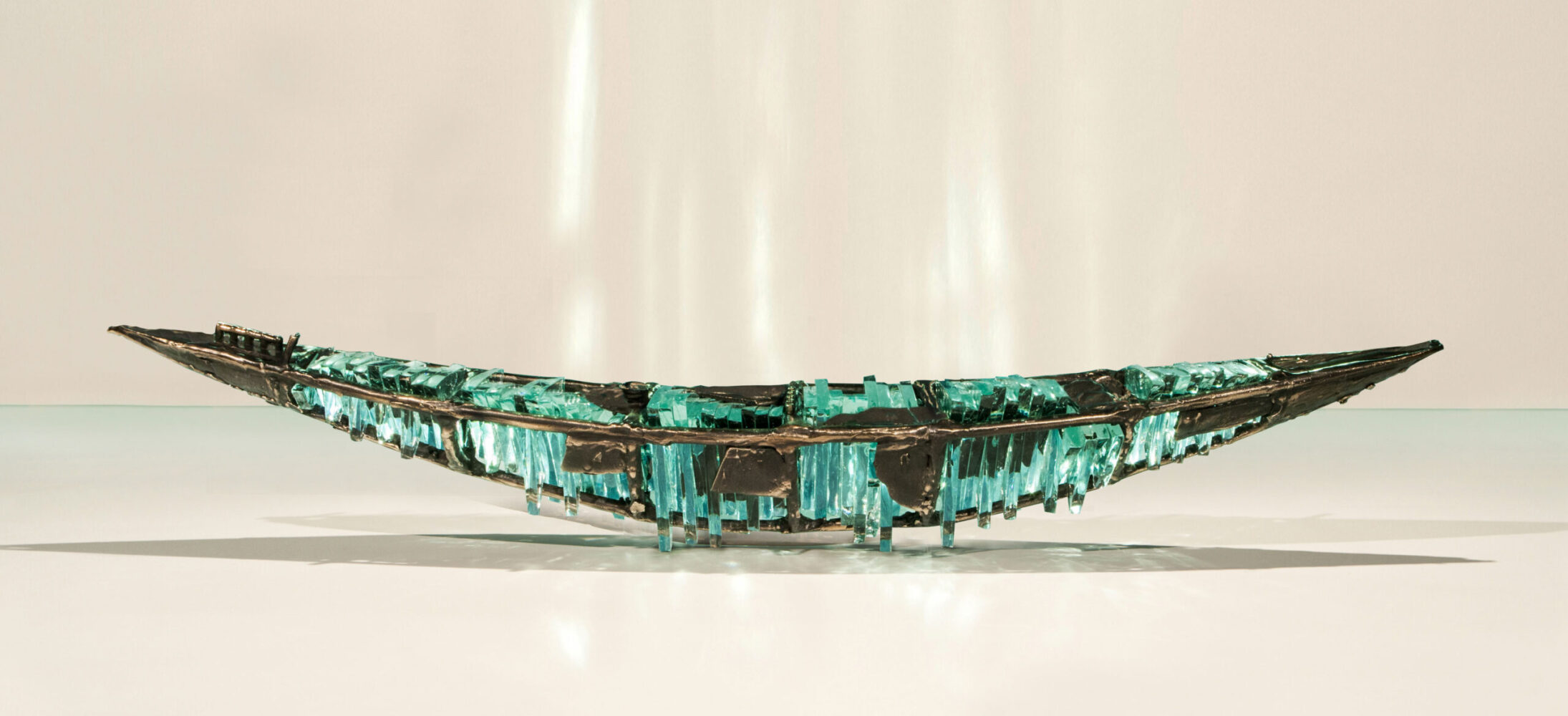 Shipwreck boat sculpture made of hand cut glass and bronze.