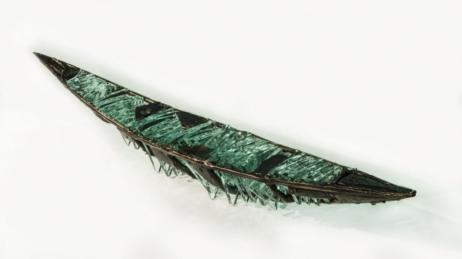 Shipwreck boat sculpture made of hand cut glass and bronze.