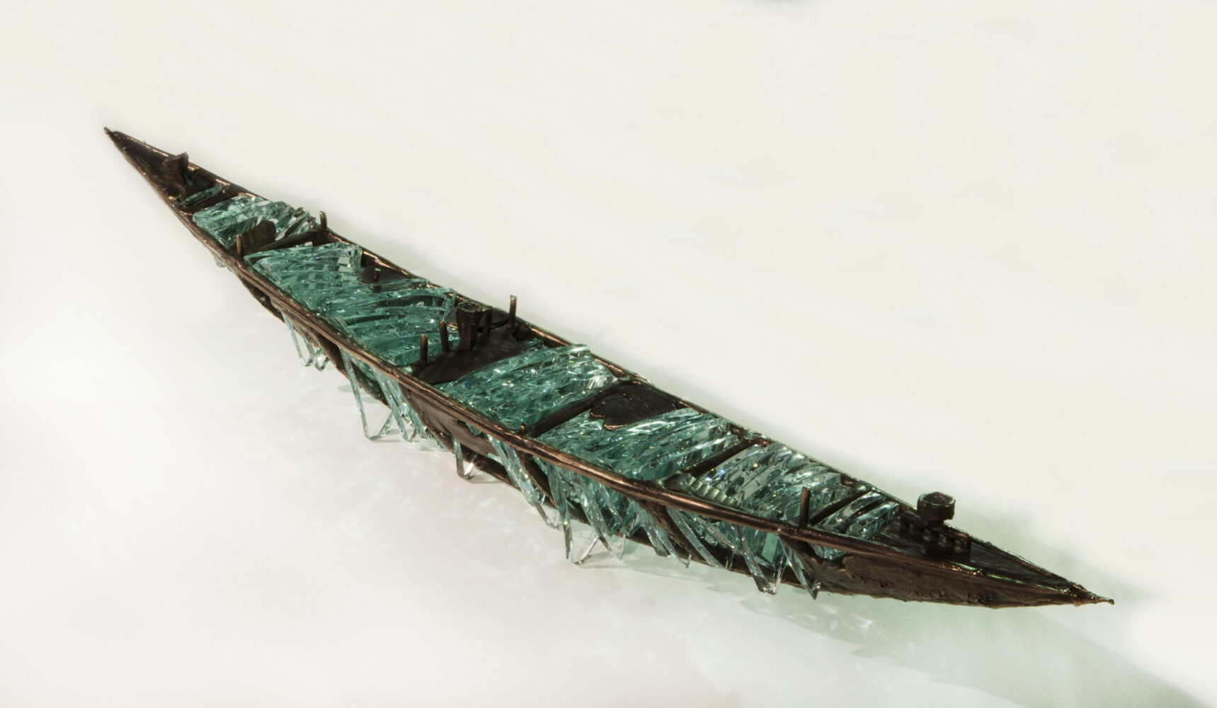 Shipwreck boat sculpture made of hand cut glass and bronze.