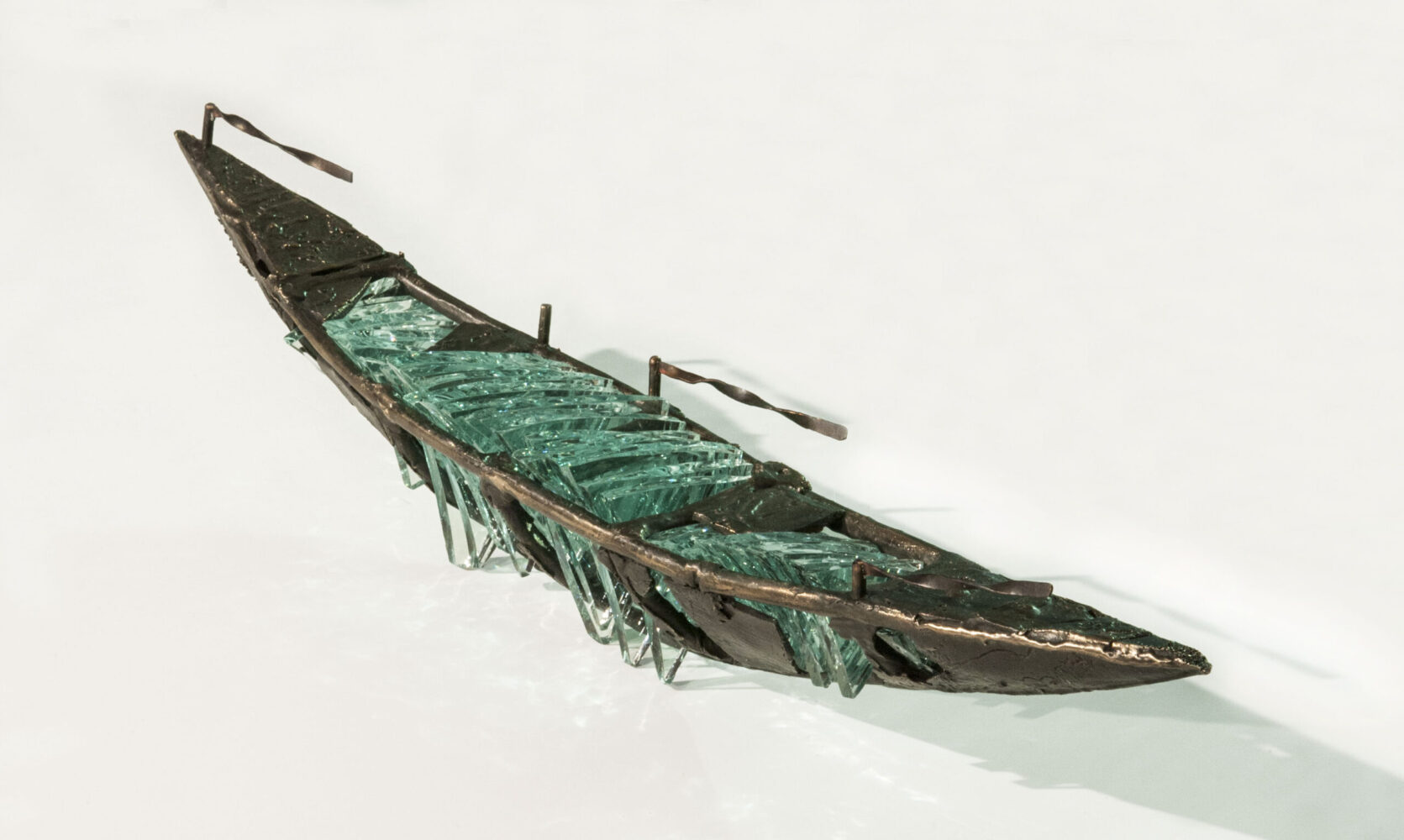 Shipwreck boat sculpture made of hand cut glass and bronze.
