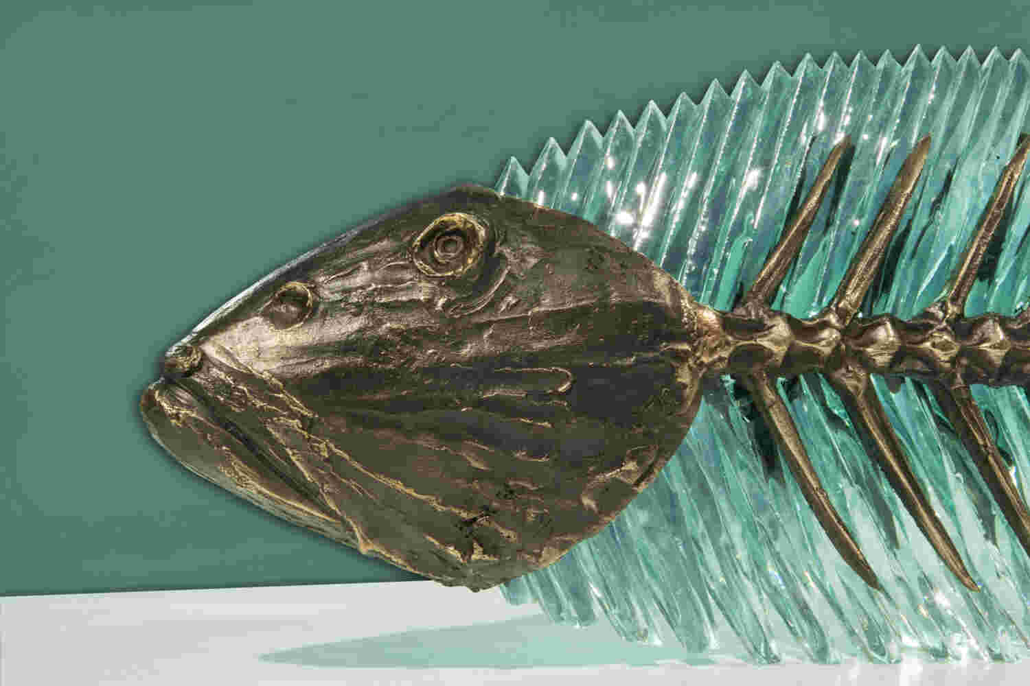 Hand cut glass and bronze sculpture of a fish.