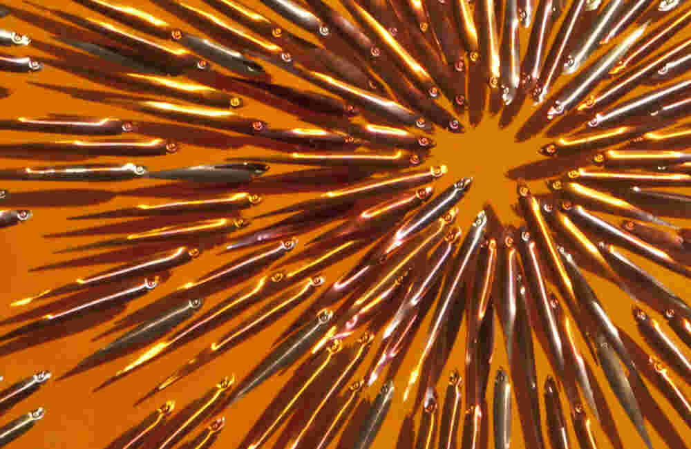 Three-dimensional wall sculpture, school of fish theme, with layers of plexiglass, aluminum frame and exploding copper fish.